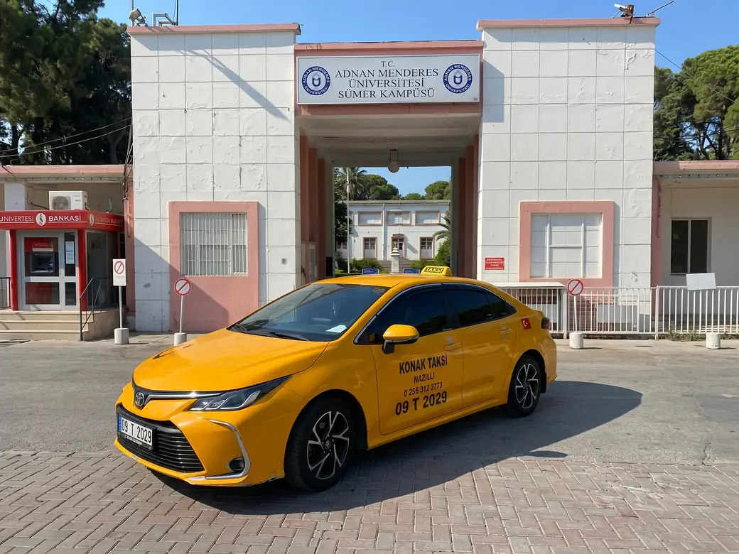 ADÜ Sümer Kampüsü girişinin önünde sarı taksi